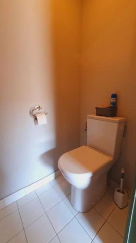 a bathroom with a white toilet with an orange wall at Maison de Village en Camargue Parking Clim Wifi - ROSSIconciergerie - Linge inclus in Saint-Laurent-dʼAigouze