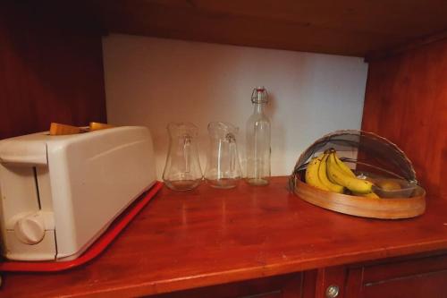 a counter with a toaster and a bowl of bananas at Maison de Village en Camargue Parking Clim Wifi - ROSSIconciergerie - Linge inclus in Saint-Laurent-dʼAigouze