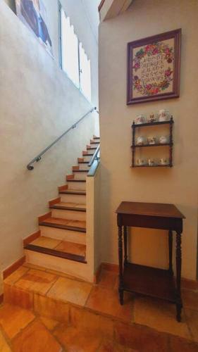 a staircase in a home with a wooden floor and a table at Maison de Village en Camargue Parking Clim Wifi - ROSSIconciergerie - Linge inclus in Saint-Laurent-dʼAigouze