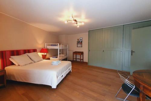 a bedroom with a bed and a desk and a table at Maison de Village en Camargue Parking Clim Wifi - ROSSIconciergerie - Linge inclus in Saint-Laurent-dʼAigouze