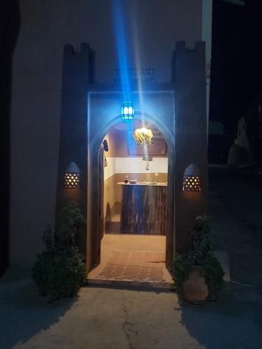 a blue light shines through an archway of a building at DAR DANI café restaurant in Boumalne