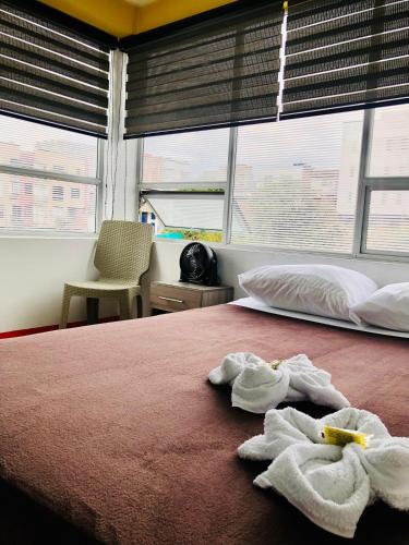 a bedroom with a bed with two towels on it at Hotel Café Color in Armenia