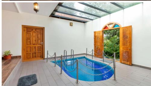 an indoor pool in a building with a blue pool at Serene Valley Resort Wayanad in Mananthavady