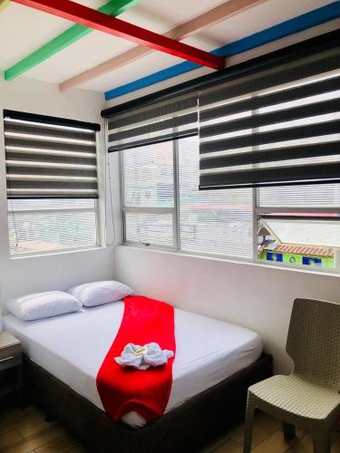 a bedroom with a bed with a red blanket on it at Hotel Café Color in Armenia
