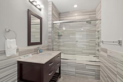 ein Badezimmer mit Waschbecken und Badewanne in der Unterkunft Luxury 1BR - Glass Wall & Window in Philadelphia
