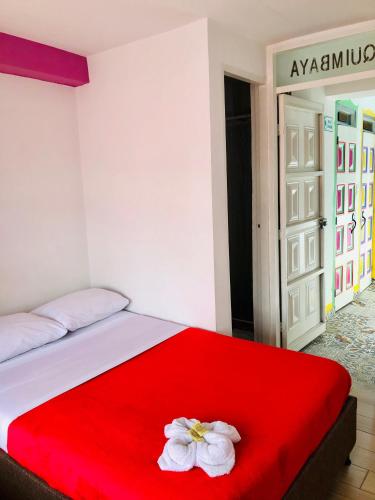 a bed with a red blanket and two white flowers on it at Hotel Café Color in Armenia