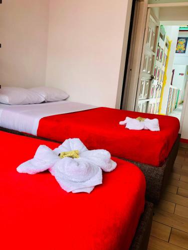two beds with towels on them in a hotel room at Hotel Café Color in Armenia