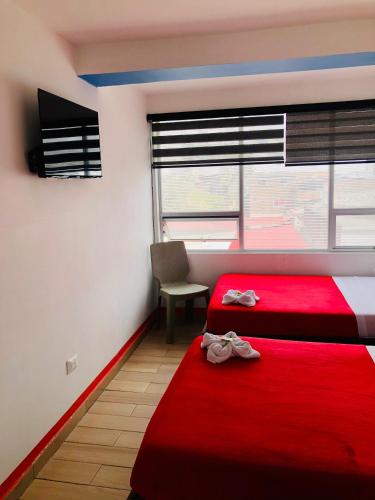 a bedroom with two red beds and a window at Hotel Café Color in Armenia