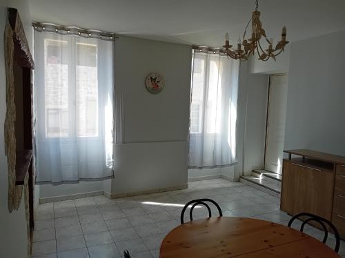 a dining room with a table and some windows at gîte à partager chambre pour 1 à 2 personnes in Cruis