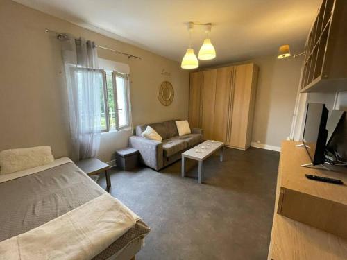 a living room with a bed and a couch at Résidence Tivoli, Trouville, 2min plage in Trouville-sur-Mer