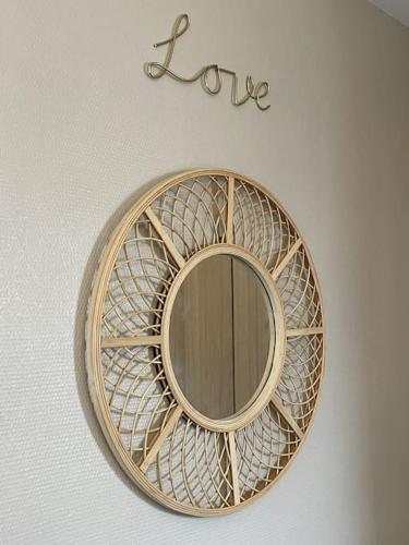 un miroir rond sur un mur avec le mot amour dans l'établissement Résidence Tivoli, Trouville, 2min plage, à Trouville-sur-Mer
