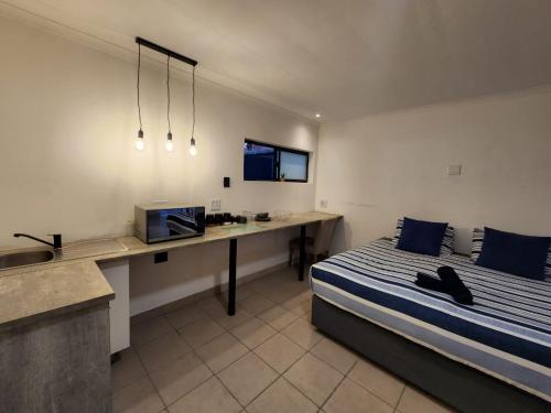 a bedroom with a bed and a desk and a television at East Park Inn in Polokwane