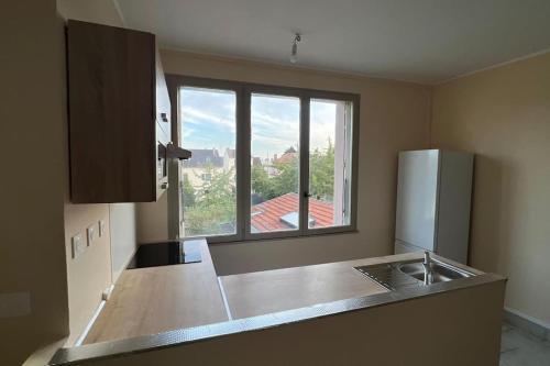 a kitchen with a refrigerator and a window at ZE Luxurious House Paris - Suite de luxe in Argenteuil
