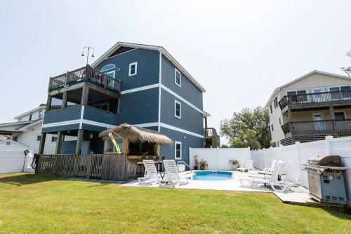 a blue house with a swimming pool in a yard at Canalfront, Private Pool, Sound Views, COL22, Island Breeze in Kill Devil Hills