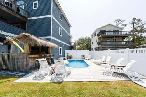 a backyard with chairs and a swimming pool at Canalfront, Private Pool, Sound Views, COL22, Island Breeze in Kill Devil Hills