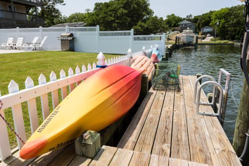 a row of kayaks on a dock next to the water at Canalfront, Private Pool, Sound Views, COL22, Island Breeze in Kill Devil Hills