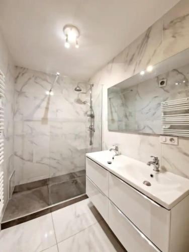 une salle de bain blanche avec un lavabo et une douche dans l'établissement Coquet appartement au Mourillon, à Toulon