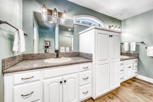 a white bathroom with a sink and a mirror at Quelah Lane 8 in Sunriver