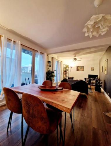 un salon avec une table et des chaises en bois dans l'établissement Coquet appartement au Mourillon, à Toulon