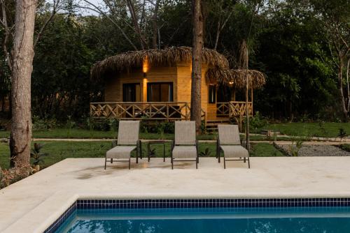 a resort with a pool and chairs and a house at Dos Mares Venao Village in Playa Venao