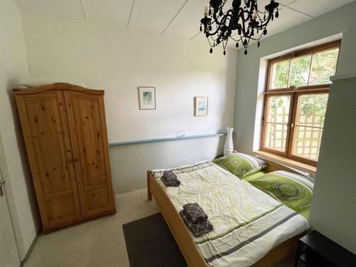a bedroom with a bed and a window and a chandelier at Holiday home in Breetz üb Lenzen in Breetz
