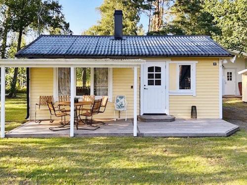a small yellow cottage with a table and chairs at 6 person holiday home in MELLBYSTRAND-By Traum in Mellbystrand