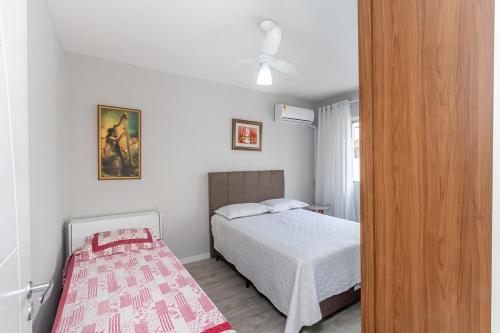 una piccola camera con letto e ventilatore a soffitto di Apto Pe na Areia, direcao Ilha-Balneario Camboriu. a Balneário Camboriú