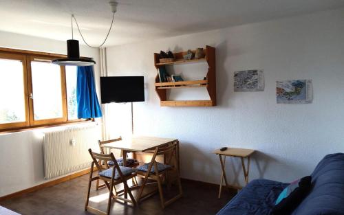 un salon avec une table et un canapé bleu dans l'établissement Résidence Plandevin - 2 pièces 4 personnes à Arc 1600 MAE-8941, à Arc 1600