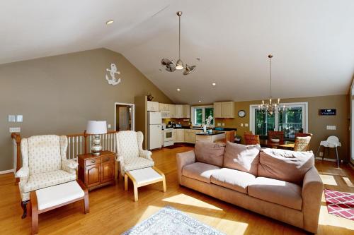 a living room with a couch and chairs and a kitchen at Turtle Cove in Glenora