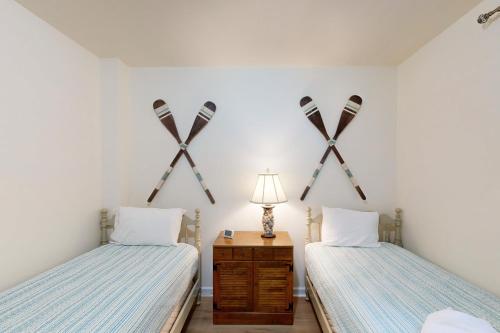 two beds in a room with crossed skis on the wall at Turtle Cove in Glenora
