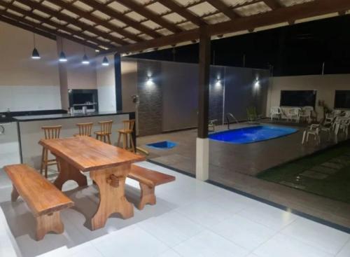 a room with a wooden table and chairs and a kitchen at Casa das Americas in Nova Almeida