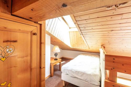 une chambre avec un lit et un plafond en bois dans l'établissement Résidence Gaillard - GAILLARD 05 MAE-4311, à Les Allues