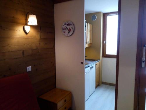 une petite cuisine avec une horloge murale dans l'établissement Résidence Creux De L Ours C - CREUX DE L OURS C44 MAE-4471, à Les Allues