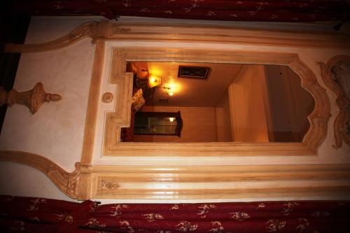 a mirror with a wooden frame on a wall at Hôtel du Fiacre in Carpentras