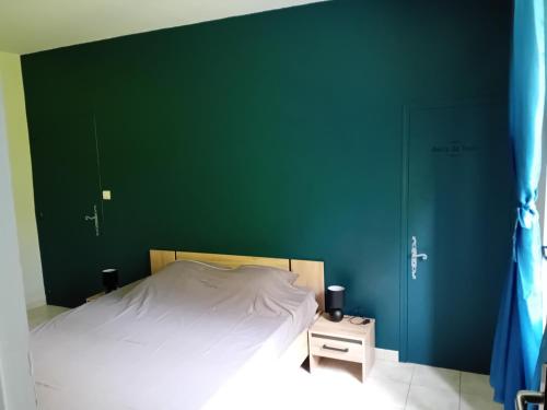 a bedroom with a green wall and a bed at gîte à partager chambre pour 1 à 4 personnes in Cruis