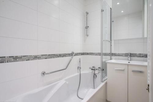 une salle de bain blanche avec une douche et un lavabo dans l'établissement Résidence Le Makalu - Résidence LE MAKALU N°11 MAE-4731, à La Plagne Tarentaise