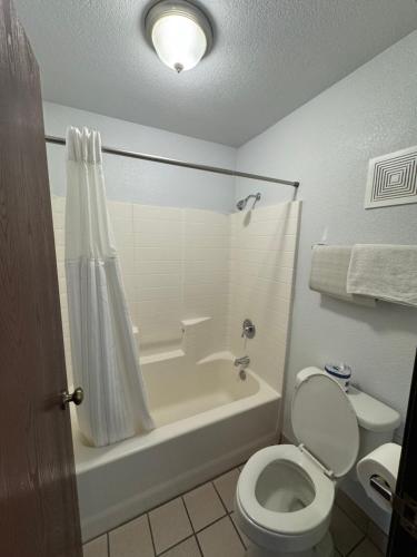 a bathroom with a tub and a toilet and a shower at The New Pioneer in Laughlin