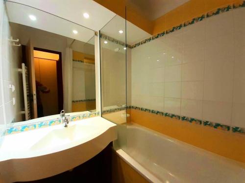 une salle de bain avec un lavabo et un grand miroir dans l'établissement Résidence Le Mont Soleil B - Résidence MONT SOLEIL B N°B510 MAE-5011, à La Plagne Tarentaise