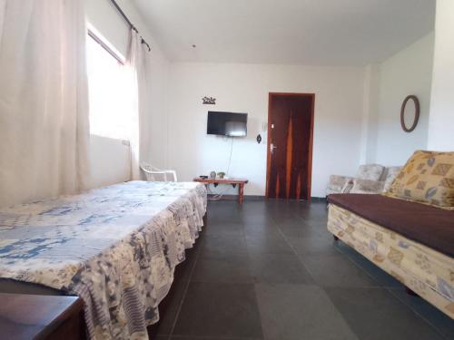 ein Zimmer mit einem Bett, einer Couch und einem Fernseher in der Unterkunft Kit ótima localização - Águas de Lindoia in Águas de Lindóia