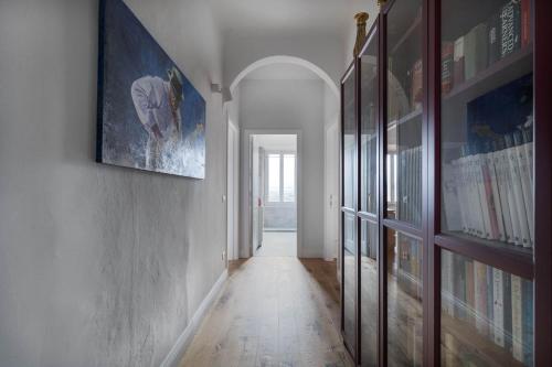 a hallway with bookshelves and a painting on a wall at Dimora San Donato in Casole dʼElsa