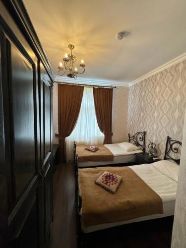una camera d'albergo con due letti e un lampadario a braccio di Xan Hotel a Baku