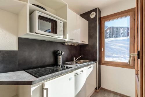une cuisine avec un évier et un micro-ondes dans l'établissement Résidence Agate - Résidence AGATE N°19 MAE-5221, à Aime La Plagne
