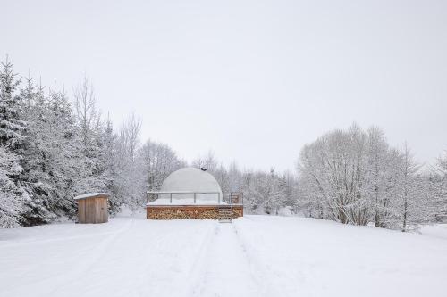 a snow covered field with a domed building in the distance at Glampingový stan Liška in Vrchlabí