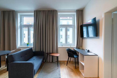 a hotel room with a couch and a table and windows at Vienna Residence, Prater - Exhibition Center in Vienna