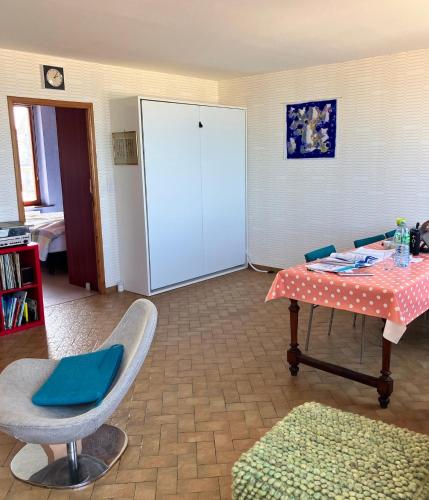 un salon avec une table et une chaise dans l'établissement unobstructed beachfront view apartment, à Bray-Dunes