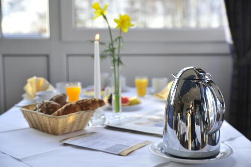 a table with a tea kettle and a basket of food at Susewind in Warnemünde