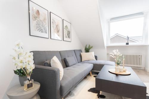 a living room with a gray couch and a table at Mc‘Maggies Atelier in Meerbusch