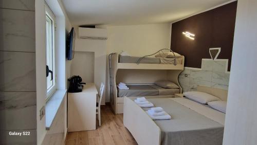 a small room with two bunk beds and a desk at Aria e sole in Caulonia