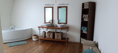 une salle de bain avec une baignoire, un lavabo et un miroir dans l'établissement La villa Duchesse proche de Malo les Bains, à Dunkerque