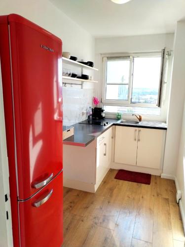 - un réfrigérateur rouge dans une cuisine blanche avec fenêtre dans l'établissement julia, à Alfortville
